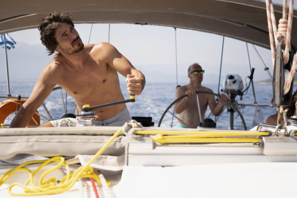 在一艘帆船上，男性的手滚动着绳子图片下载