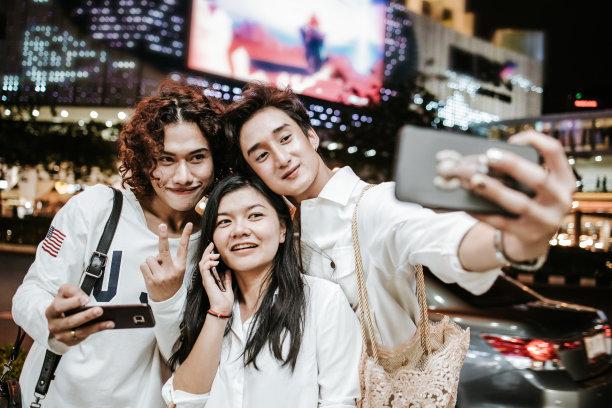 泰国黑帮在工作后享受城市生活，与手机库存照片自拍图片下载