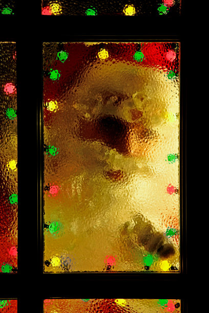 圣诞老人敲着窗户，从被灯光照亮的窗户往外看图片下载