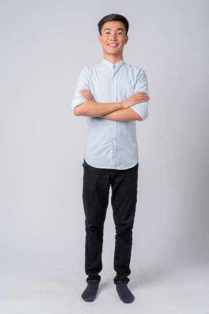 面带微笑、双臂交叉的快乐年轻亚洲商人全身照图片下载