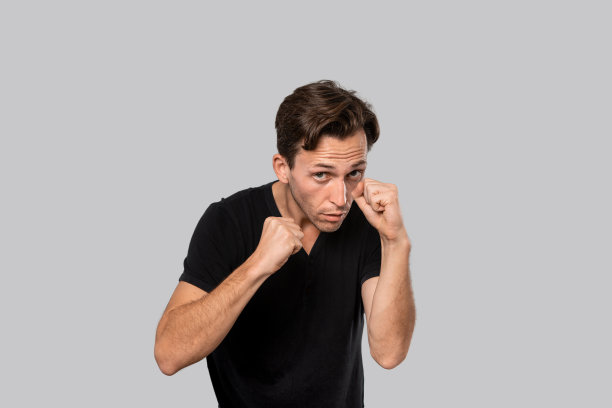 准备战斗的人站在一个拳击姿势孤立在灰色的背景。为自己辩护图片下载