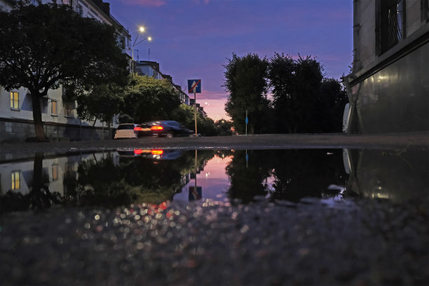 低镜头的水坑，同时下雨与交通图片下载