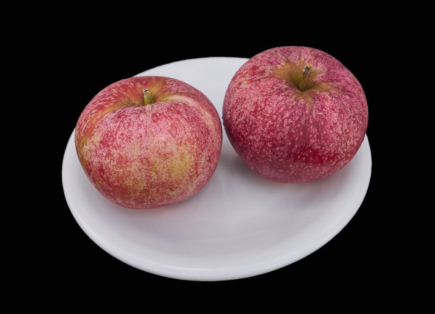 两个红苹果在一个盘子上，孤立在黑色，靠近。图片下载