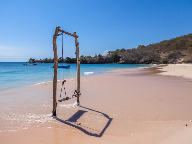 龙目岛——粉红色海滩上的木制秋千图片下载