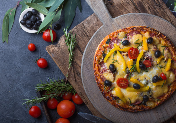 意大利传统美食，披萨，美食背景。木桌上放着新鲜烤披萨，配火腿和芝麻菜。餐厅菜单照片，披萨店，食物食谱，披萨送货理念图片下载