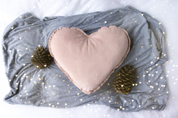 空白的粉红色心垫周围的松果和心灯-舒适浪漫的冬季圣诞场景图片下载