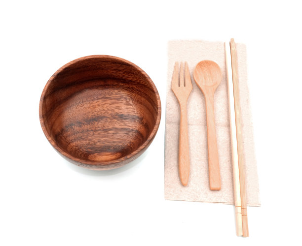 木制的筷子、勺子和叉子放在回收的棕色餐巾上，准备上桌。在白色背景上隔离图片下载