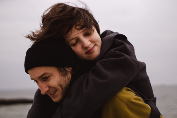 一对浪漫的情侣在海滩上玩耍。一对快乐的情侣在沙滩上跑步图片下载