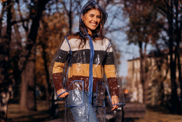 秋日户外，穿着透明雨衣的快乐女人图片下载