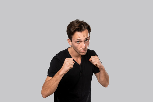 准备战斗的人站在一个拳击姿势孤立在灰色的背景。图片下载