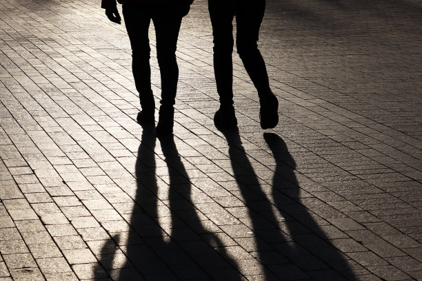 两个苗条女孩的剪影和影子走在街上图片下载