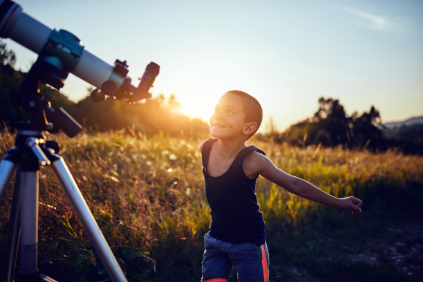 小男孩在自然界用望远镜探索宇宙。图片下载