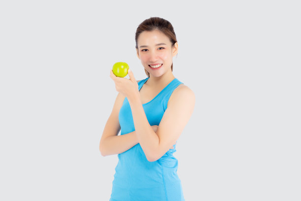美丽的肖像年轻的亚洲女人在运动服装满意和抱着绿色的苹果孤立在白色的背景，女孩亚洲有形状和健康，运动适合健康的概念。图片下载