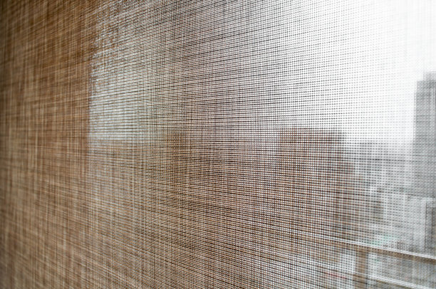 特写棕色卷帘窗帘。阳光透过城市的窗户。软焦点的形象。图片下载