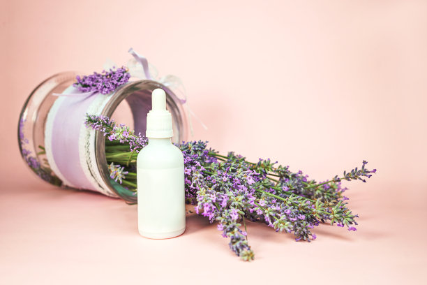 天然的化妆品。清新的薰衣草花和一瓶精油或精华液，粉底。图片下载