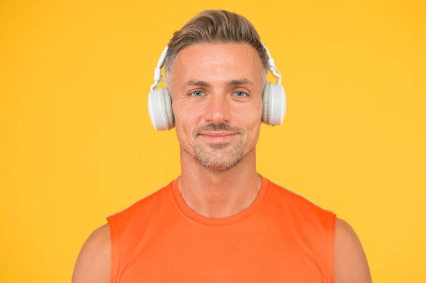 无线是现代的。干净的声音。现代技术。成熟男人听音乐无线小玩意黄色背景。时髦的人喜欢使用现代无线耳机。要无线的自由。有声书图片下载