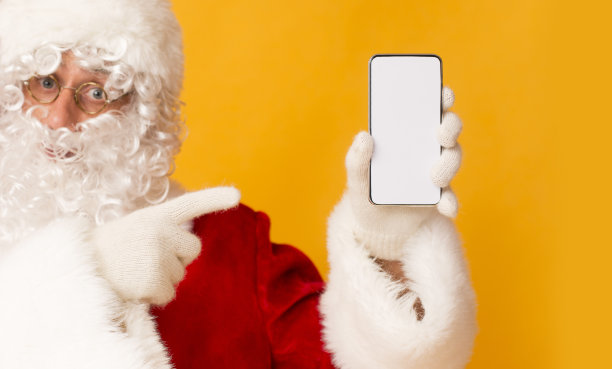 圣诞老人拿着黑白屏幕的现代手机图片下载
