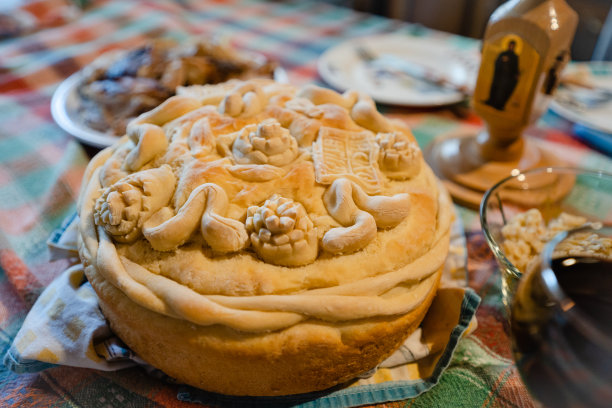 近距离观看塞尔维亚的传统正统斯拉瓦面包，在家里的餐桌上有肉，煮过的小麦和葡萄酒图片下载