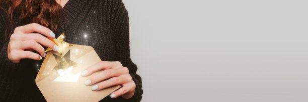 穿深色毛衣的女孩拿出金色星星的花环图片下载