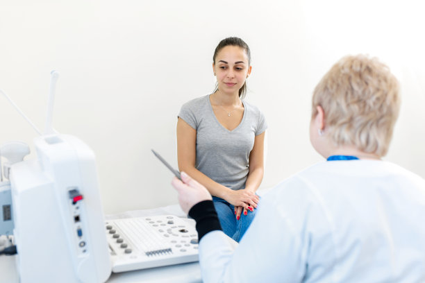 医生脸上带着微笑，在超声诊断后咨询一个女孩病人。专业的医学检查。图片下载