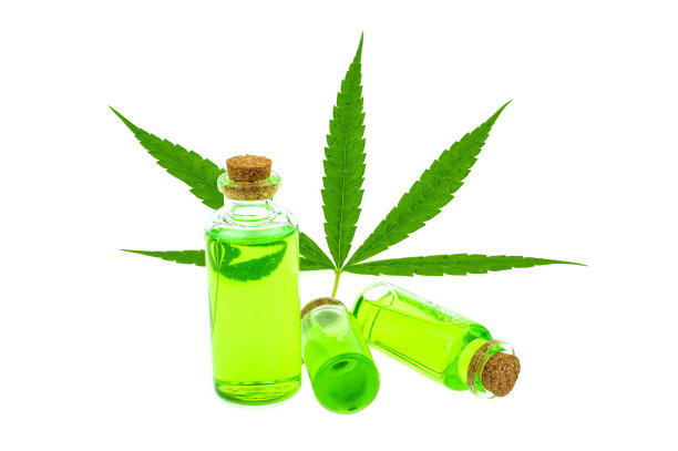 玻璃瓶与CBD油和大麻叶在背景，医疗大麻概念图片下载