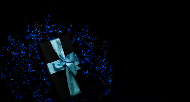礼盒在黑色背景与蓝色火花。新年假期概念图片下载