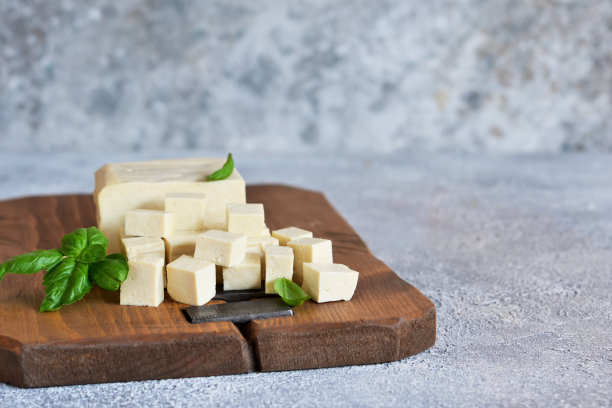 大豆奶酪——经典的豆腐奶酪放在厨房桌子的木板上。图片下载