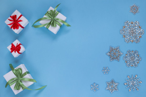 圣诞礼物和雪花孤立在蓝色的背景。为你的文本复制空间。图片下载