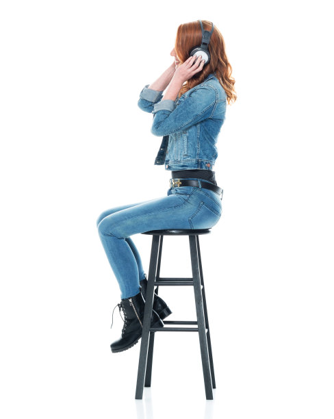 侧视图/侧面视图/一人/全长20-29岁的成年人漂亮的红发/长发白种人女性/年轻女性坐/休息谁是微笑/快乐/愉快/大笑/听和使用耳机图片下载