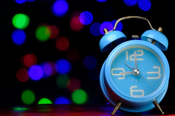 蓝色复古闹钟与彩色的散景背景图片下载