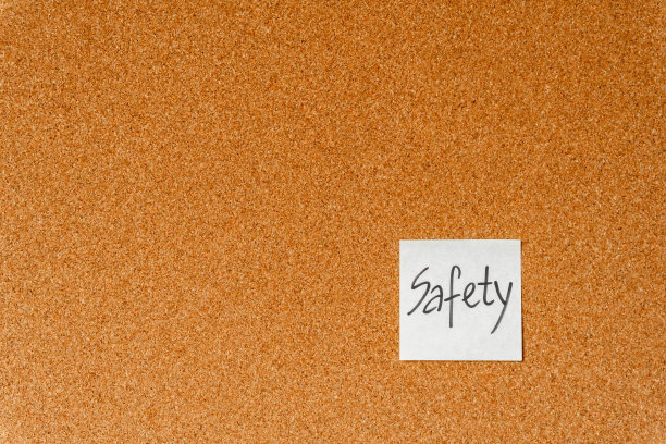 安全问题，软木板上的纸贴纸。办公室工作中的安全观念。背景。图片下载