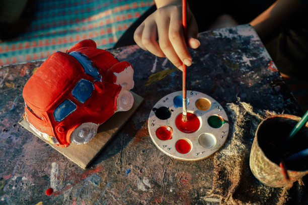儿童着色汽车雕像石膏复古风格。彩色水彩托盘和画笔。图片下载