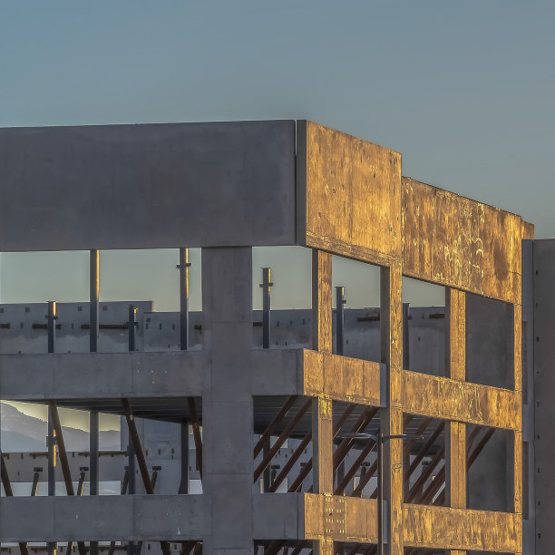 在日落时分，以山和天空为背景的现代建筑图片下载