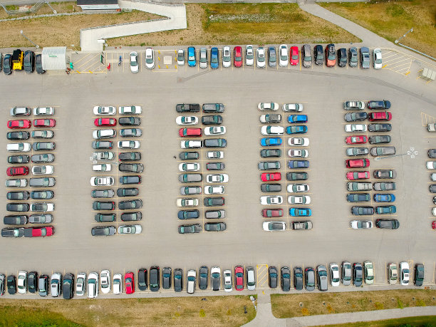 夏天通勤火车附近的停车场挤满了汽车。鸟瞰图。停车场挤满了汽车。市民离开那里的汽车，乘火车去城市。图片下载
