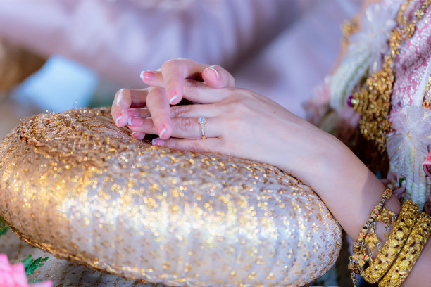 女人的手显示与钻石戒指。她订婚了。订婚戒指插入手指的照片。女人手上戴着一枚钻石戒指图片下载