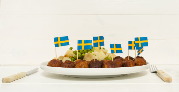 传统的瑞典肉丸(kottbullar)与花椰菜和绿豌豆在白色盘子。瑞典的国旗。瑞典民族食品概念。背景照片与文字的地方。图片下载
