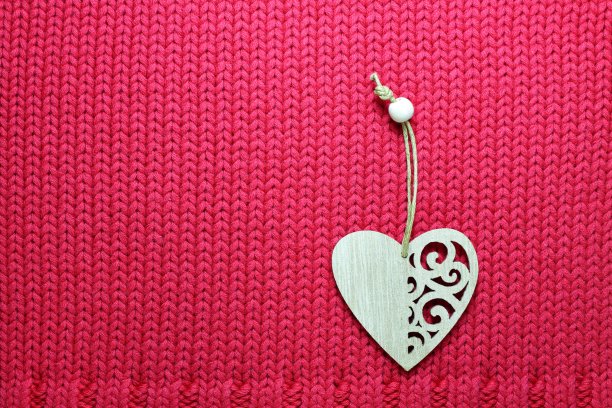 情人节贺卡。节日背景与粉红色编织纹理和两心与patters。图片下载