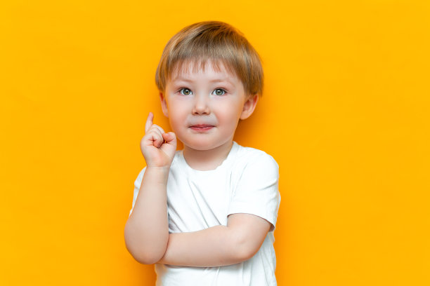 可爱英俊的金发小男孩的肖像，手指向上。小孩子有主意。孩子被隔离在黄色的黑土上。成功，聪明的想法，创造性的想法图片下载