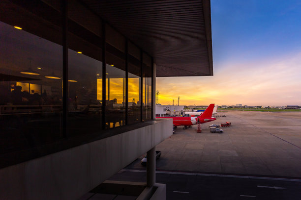 日出的景色就像日落在机场与飞机，飞机降落后起飞前，在登机口和餐厅在候机楼与等待乘飞机旅行的人图片下载