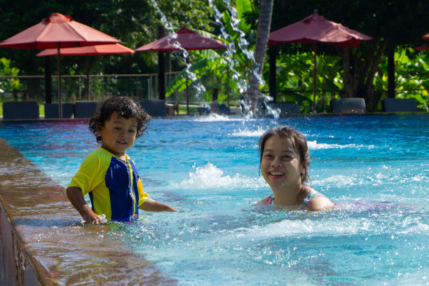 亚洲小孩和妈妈在游泳池里学习游泳图片下载