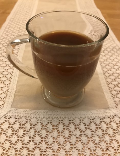 玻璃咖啡杯放在蕾丝桌腿上图片下载