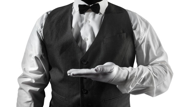 服务员穿着白衬衫和黑色马甲显示手上的copyspace。图片下载