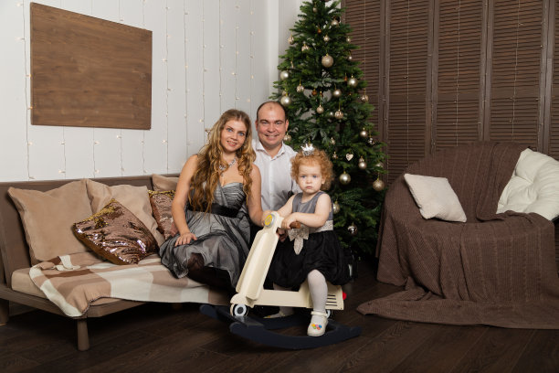美丽年轻幸福的一家人带着孩子在除夕的沙发上。新2020年图片下载