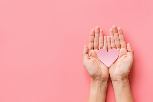 情人节的背景。女人的手捧着粉红色的壁炉。平铺，俯视图，模型，模板，复制空间。2月14日庆祝活动的最小抽象作品图片下载