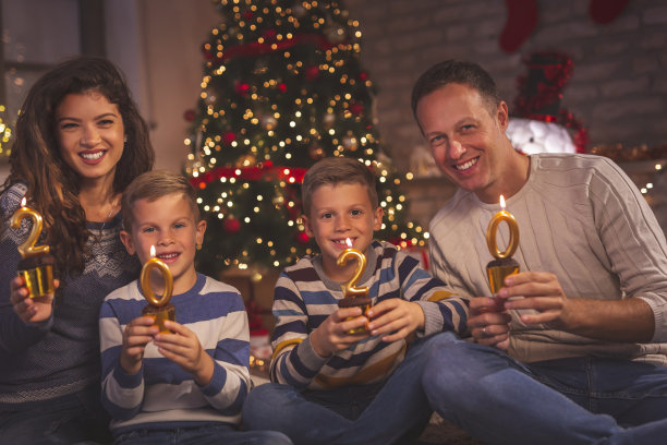 一家人拿着蜡烛纸杯蛋糕庆祝2020年新年图片下载