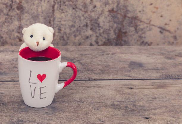 白红色的杯子，有爱和心，黑咖啡和泰迪熊。背景和壁纸采用简单简约的复古风格。爱的照片和咖啡爱好者的概念。祝你有愉快的一天。图片下载