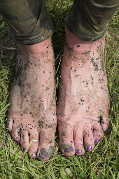 泥泞的脚站在草地上图片下载