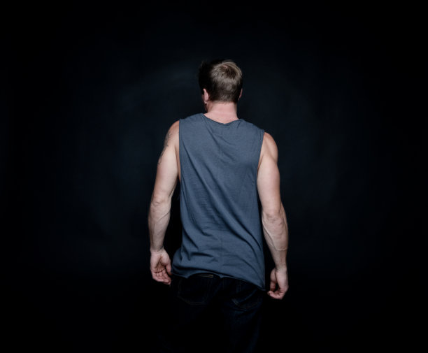 只一个人/一个人/腰/背面视图/背为20 - 29岁的成人英俊的人/短发白人男性/年轻人无袖黑色背景前穿背心、牛仔裤、裤子的性感/肌肉发达图片下载