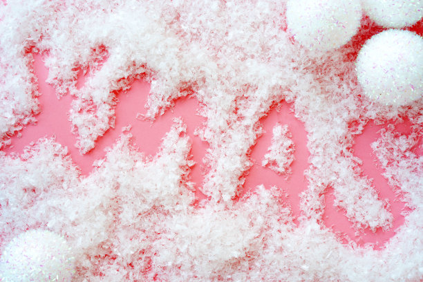 圈圣诞球在粉红色的人造雪的背景和题词圣诞图片下载