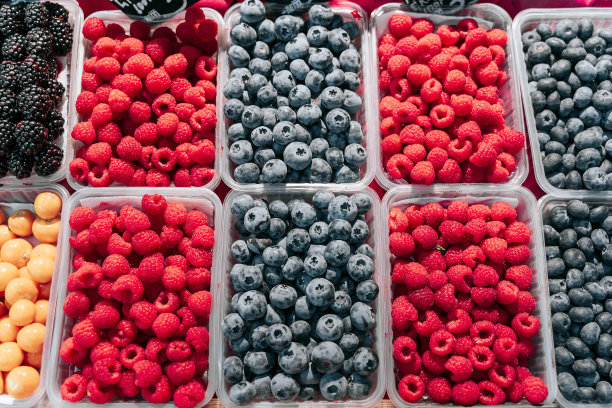 市场摊位上陈列的新鲜浆果。蓝莓、树莓、黑莓。图片下载
